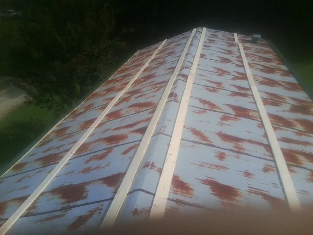 Rusted metal roof panels with new wood purlins before replacement — Storm Damage Roof Repair in Rogers by Roofing Brothers
